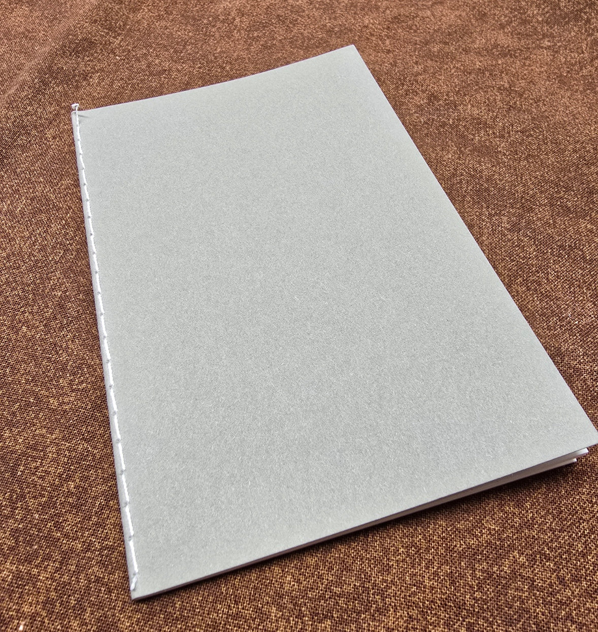 Gray notebook on a brown textured surface