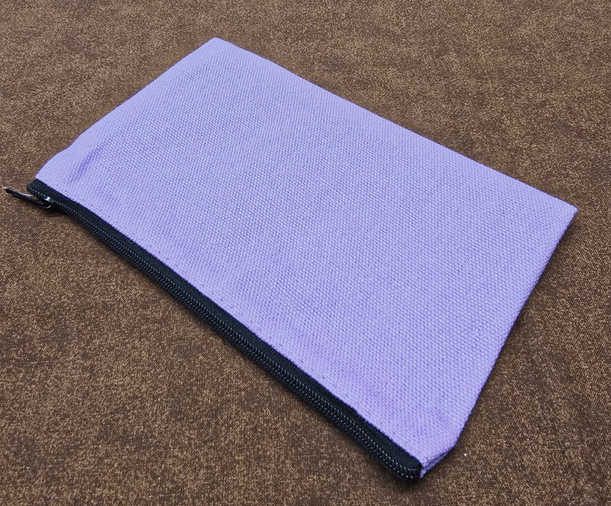 Purple zippered pouch on a brown textured surface