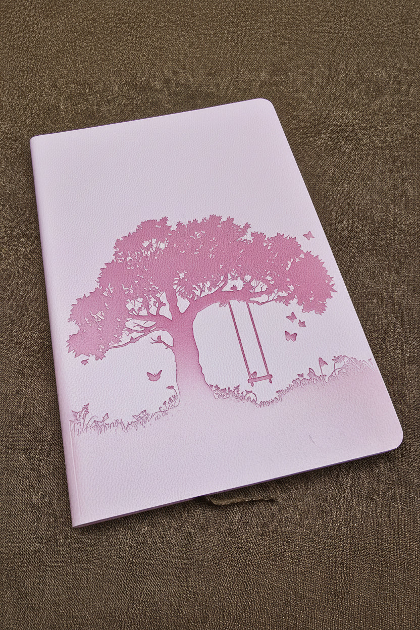 Pink journal with tree and bench design on a brown textured surface