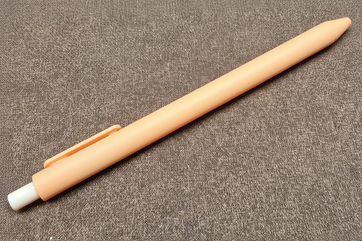 Orange pen on a textured brown surface