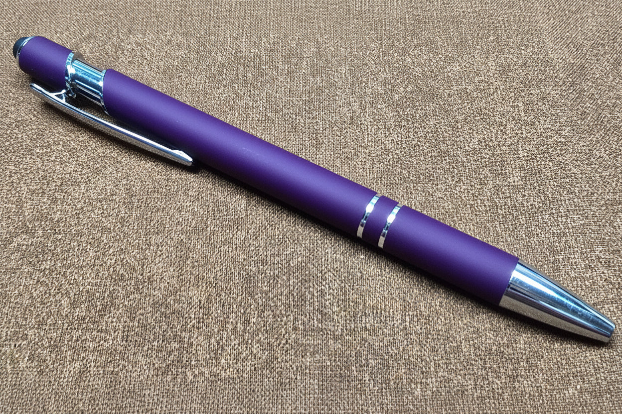 Purple pen with silver accents on a textured surface